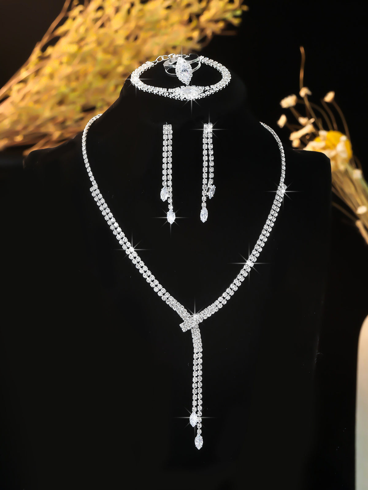 Silver-tone lariat necklace and drop earrings on a black display bust