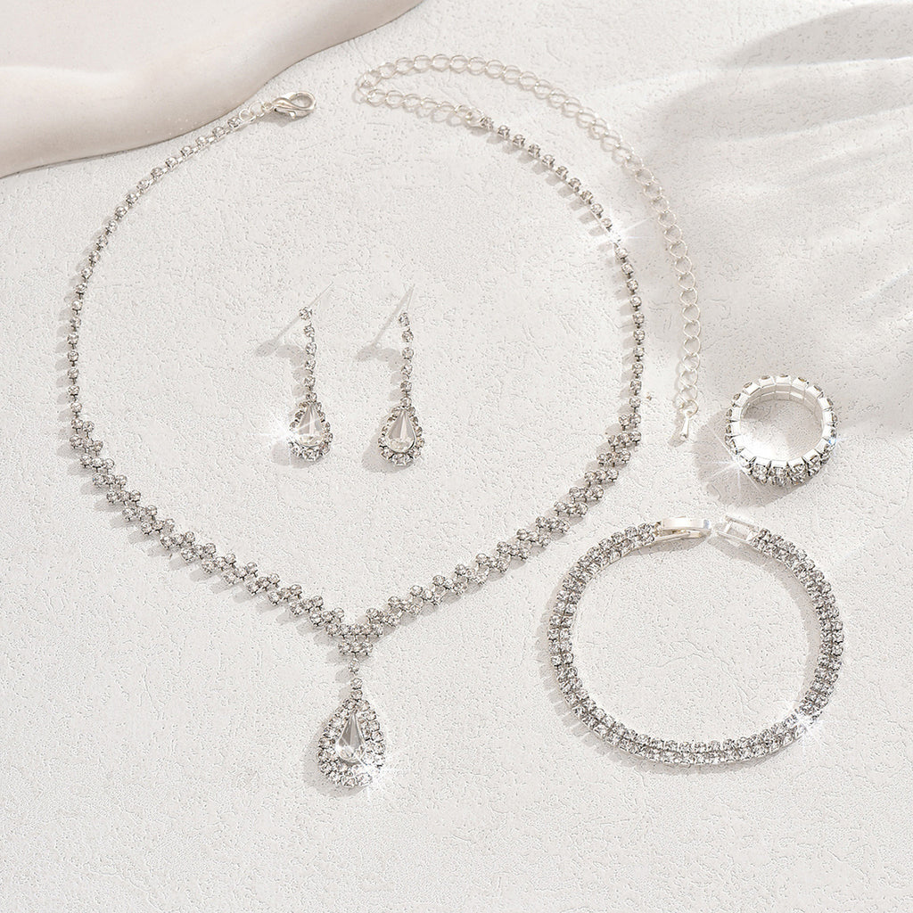 Teardrop rhinestone necklace, earrings and ring laid flat