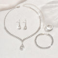 Teardrop rhinestone necklace, earrings and ring laid flat