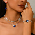 Royal blue heart rhinestone necklace, earrings and bracelet worn by a model