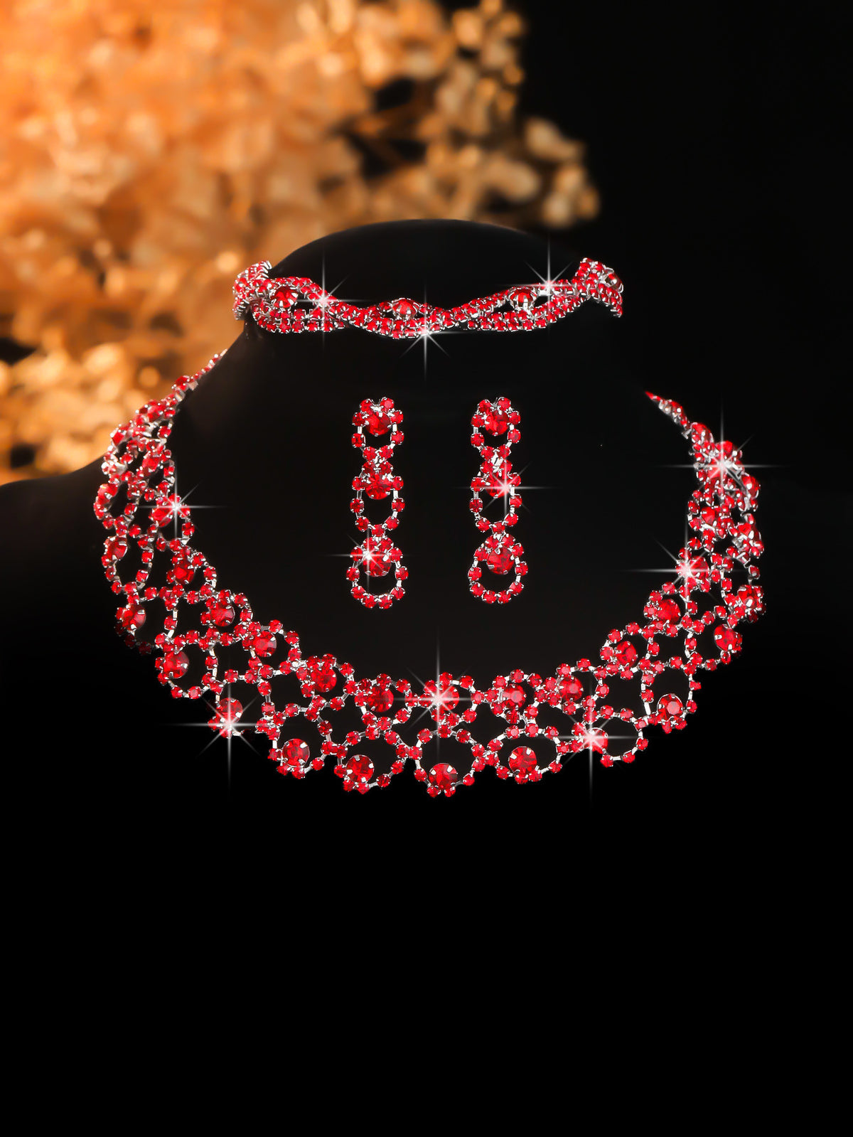 Red stone-set collar necklace and earrings on a black display bust
