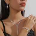 Silver-tone lariat necklace, earrings and bracelet worn by a model