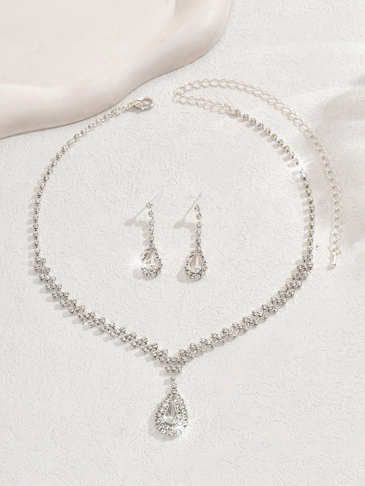 Teardrop rhinestone necklace and earrings laid flat