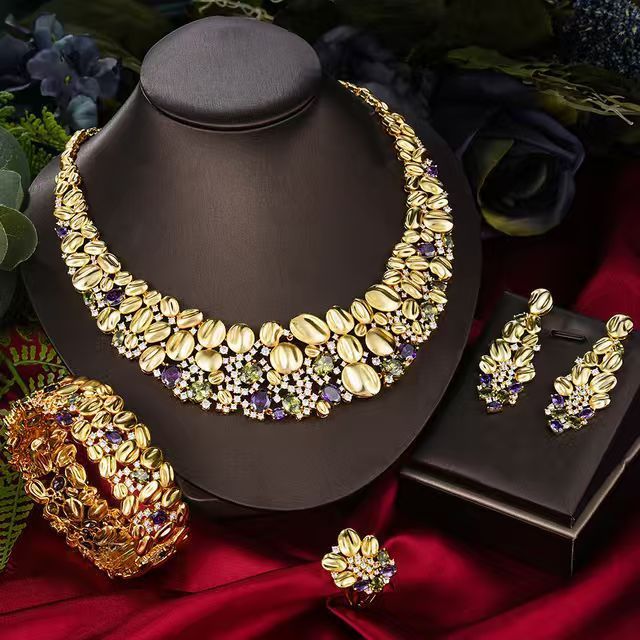 Oversized gold-tone necklace set with purple stones on a display bust
