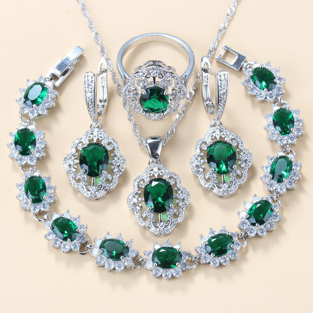 Green cubic zirconia necklace, earrings, ring and bracelet laid flat