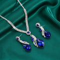 Royal blue crystal heart necklace and earrings on green satin