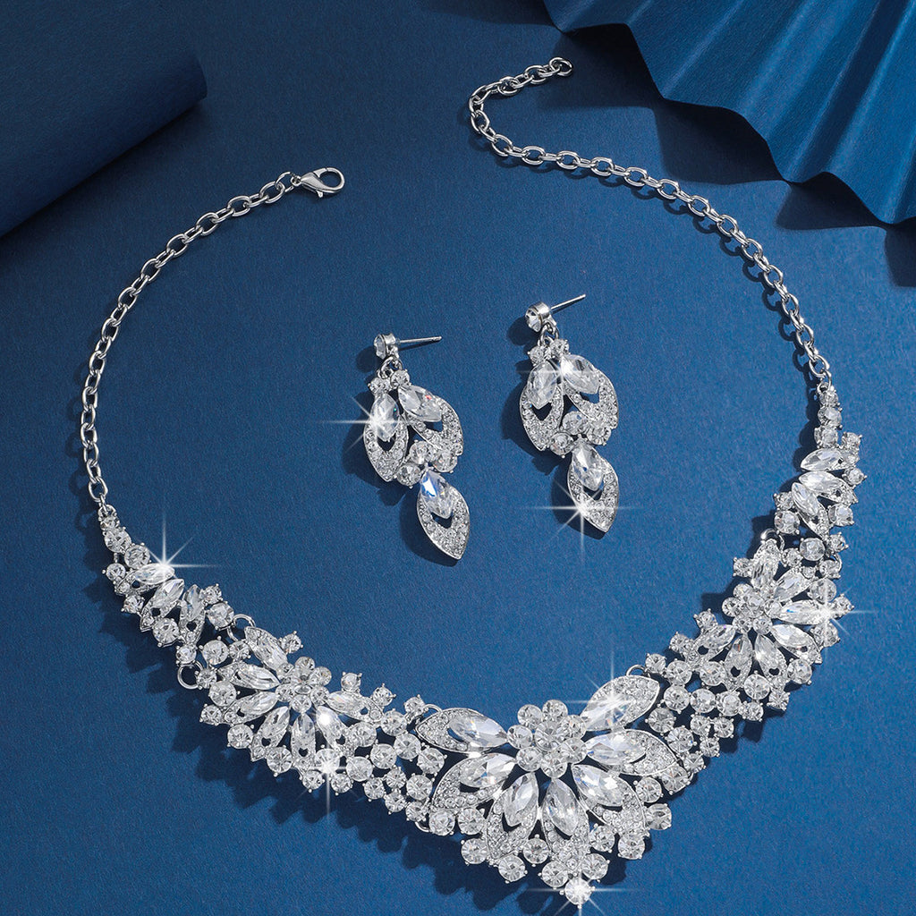 Clear rhinestone bridal necklace and matching earrings on a blue background