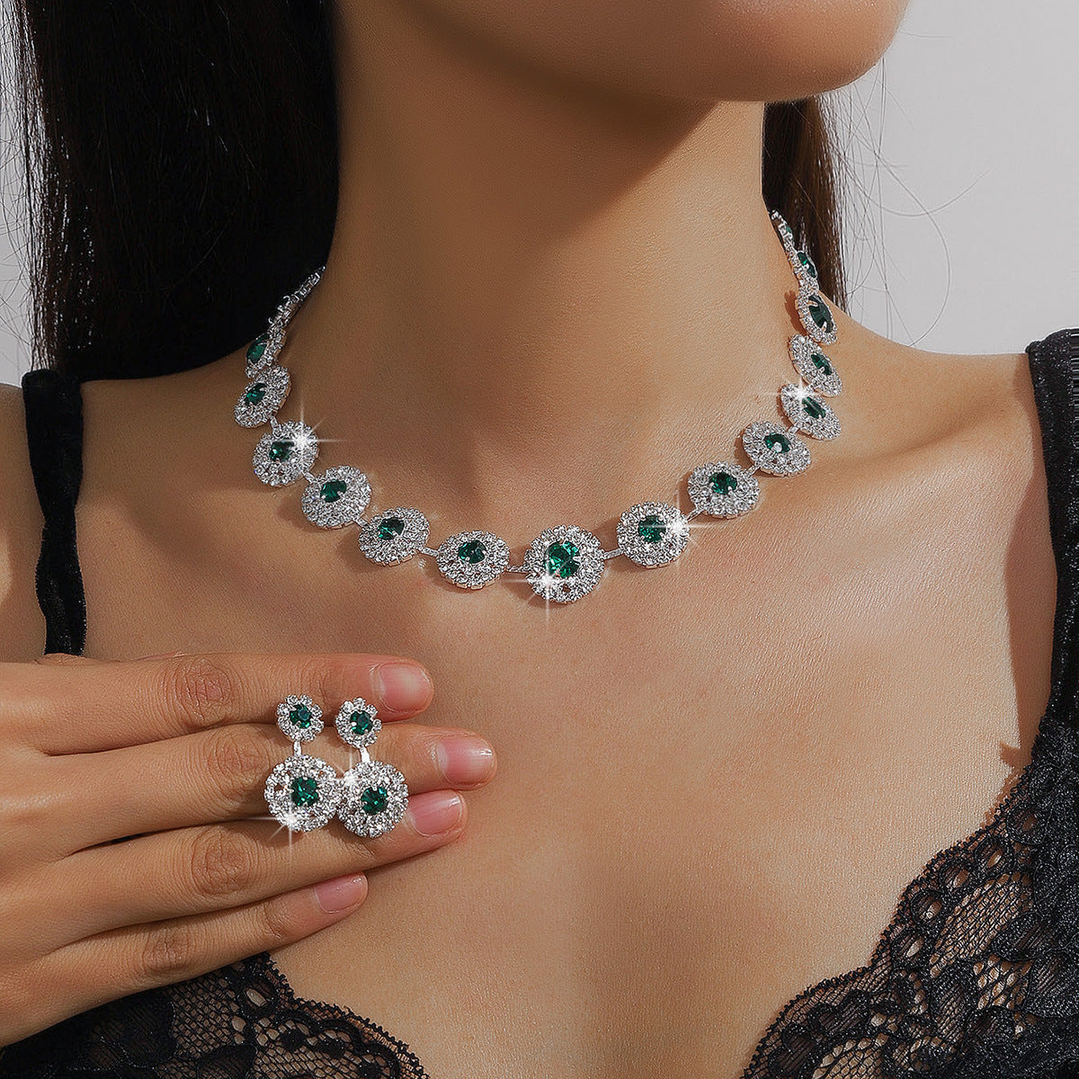 Green stone rhinestone necklace and earrings worn on a model