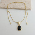 Gold-tone snake chain necklace with black onyx pendant