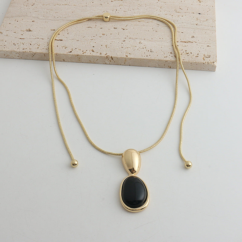Gold-tone snake chain necklace with black onyx pendant