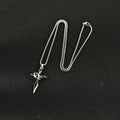 Titanium steel cross pendant with chain on a white background