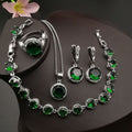 Green round stone necklace, earrings, ring and bracelet on a black display