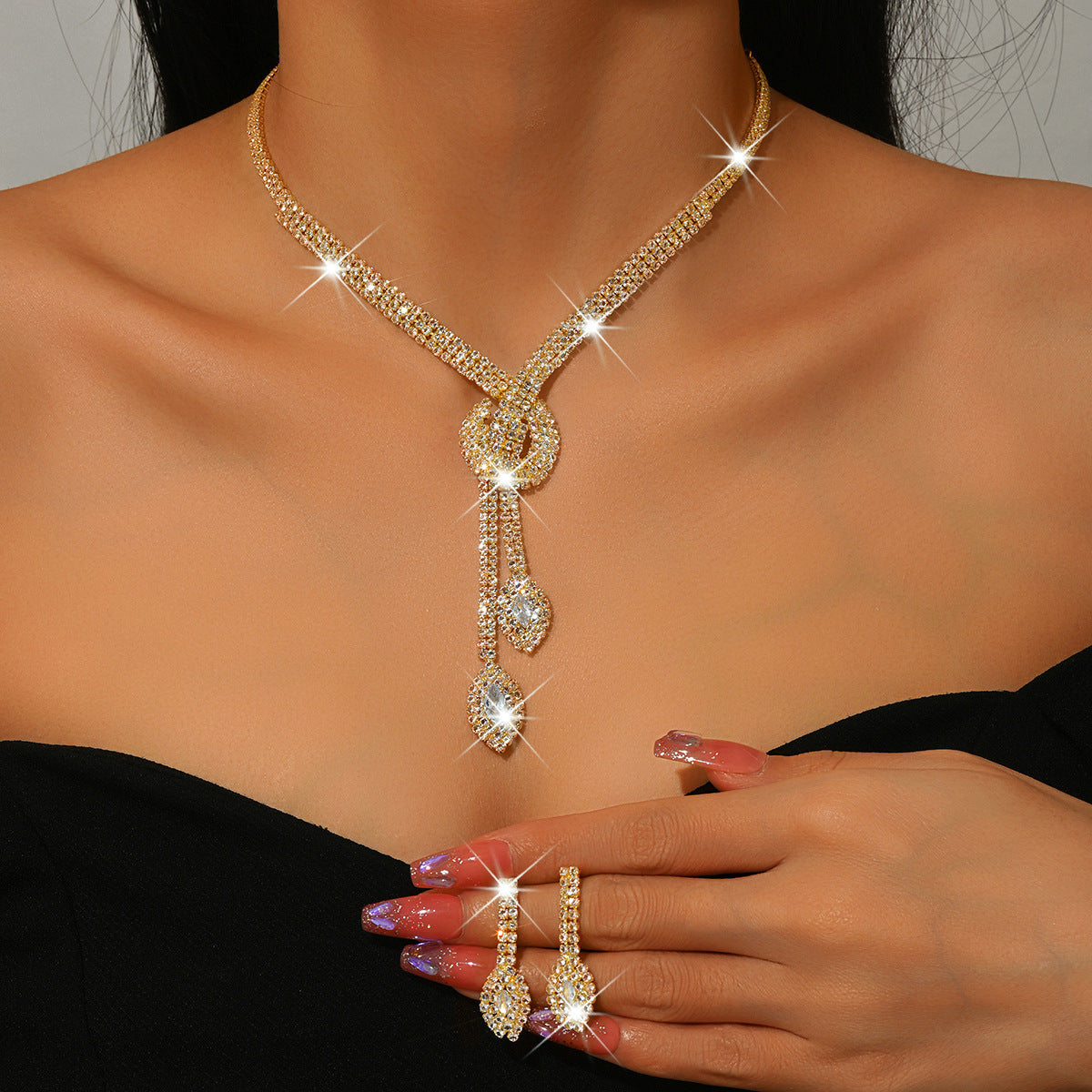 Gold-tone teardrop zircon lariat necklace and earrings worn by a model