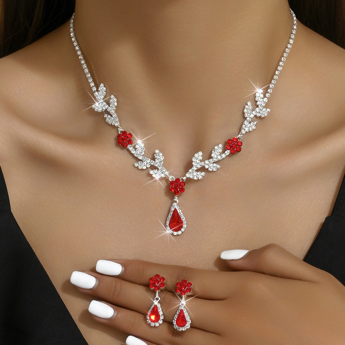 Red flower teardrop necklace and earrings worn by a model