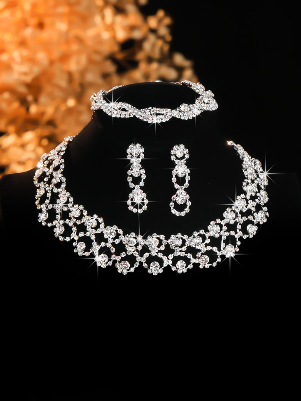 Silver-tone stone-set collar necklace and earrings on a black display bust